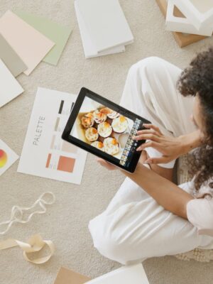 Woman in White Shirt Holding Black Tablet Computer